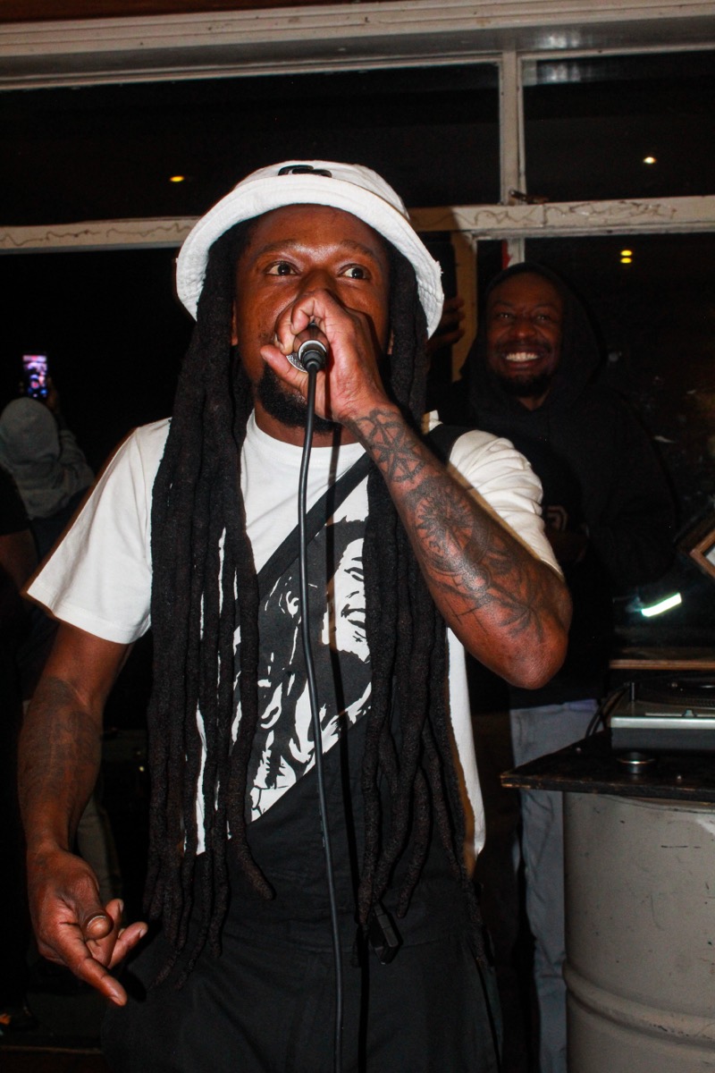 Performer with long locs rapping into the mic