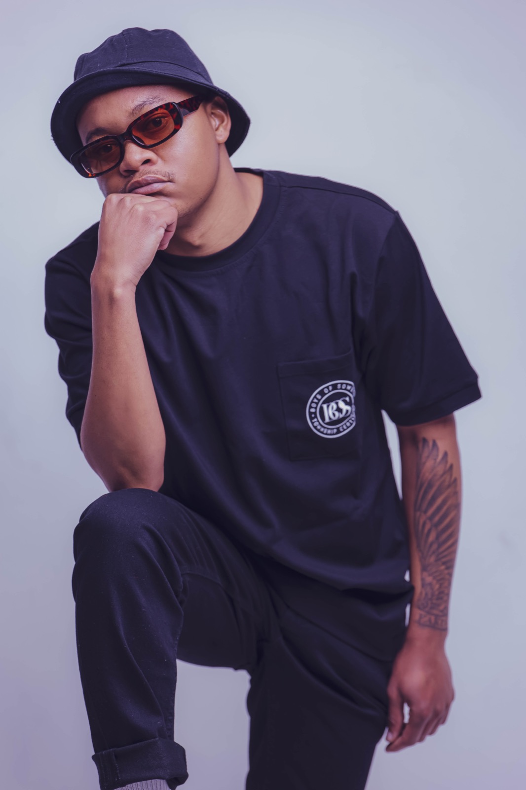 Mthizo in a black bucket hat and tinted glasses