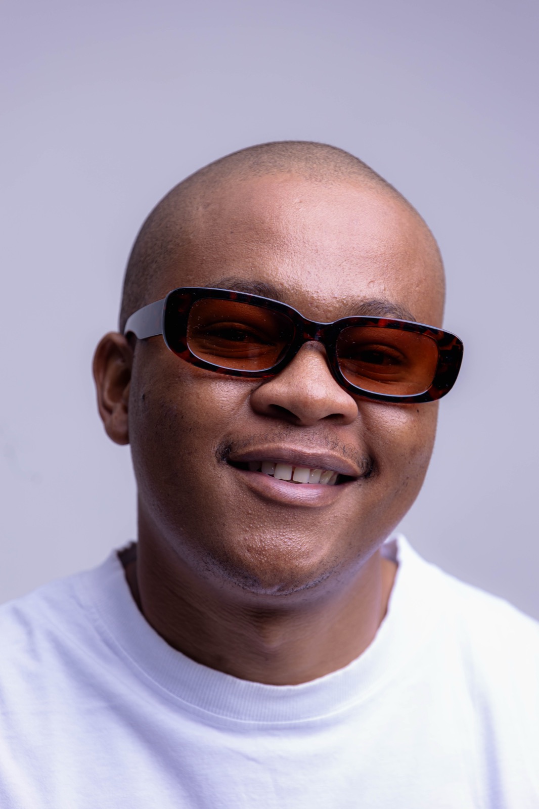 Mthizo smiling in tinted glasses